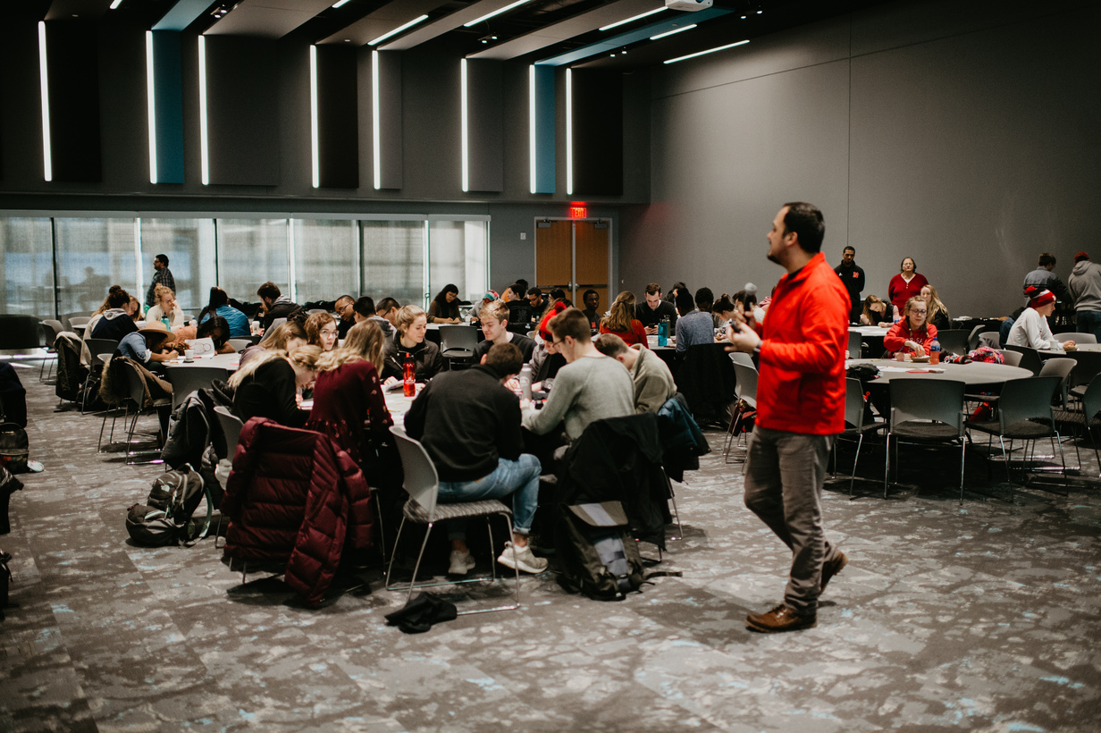 Students work together in groups as workshop coordinator speaks.