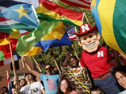 Herbie Husker with international students carrying a variety of country flags.