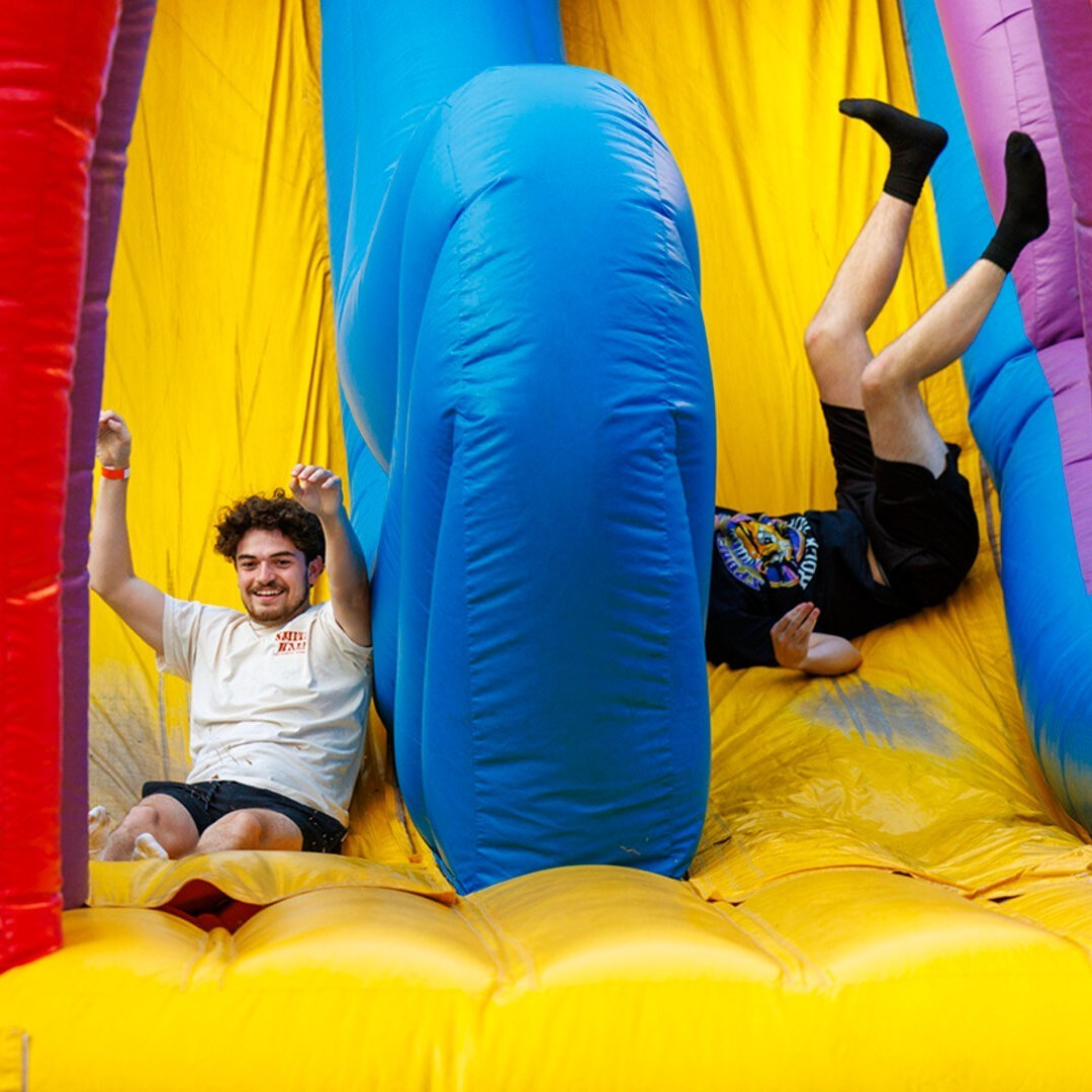 Two students complete an inflatable obstacle course at the End of Year Bash