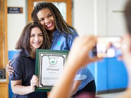 4-H leader and youth participant smiling for photo with certificate