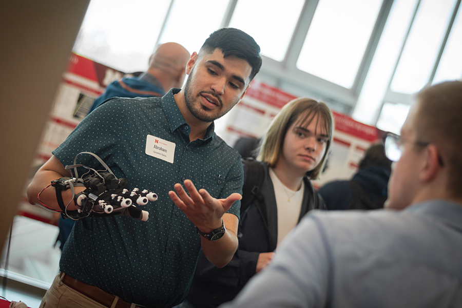 Abraham Cervantes Garcia demonstrates his team&rsquo;s robotic glove during the 2025 Senior Design Showcase at Kiewit Hall. 