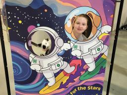 A 4-H youth and her rabbit behind a face cut out banner at the 2026 4-H Spring Rabbit Show.