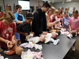 Participants at a previous Babysitting Training practicing changing diapers.
