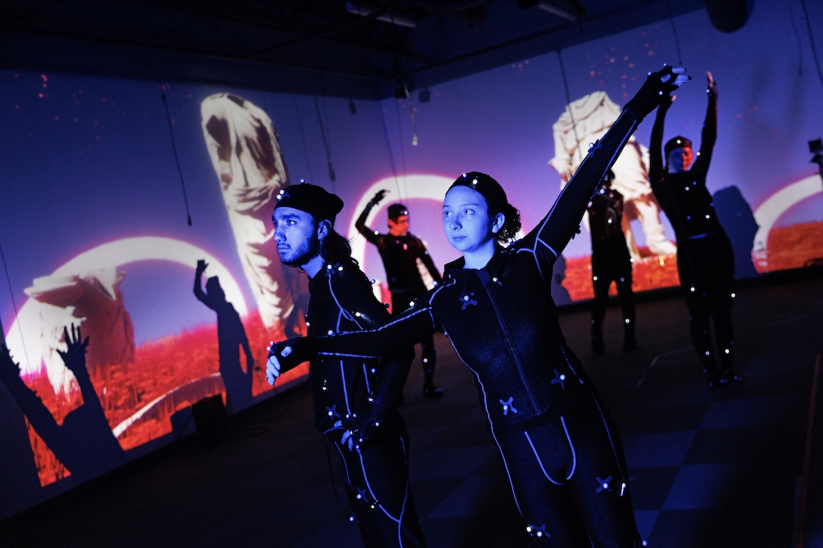 UCARE students in lighted costumes engage in a creative arts performance. (Photo credit: Craig Chandler, University Communications