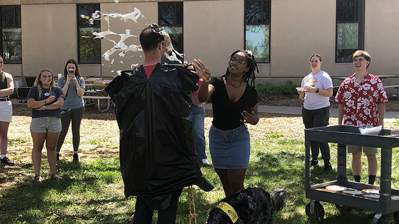 Riah Hatten (on right) throws a pie in the face of Kenneth Pyle as part of a student fundraiser during an Earth Day celebration in the School of Natural Resources. 