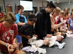 Participants at a previous Babysitting Training practicing changing diapers.