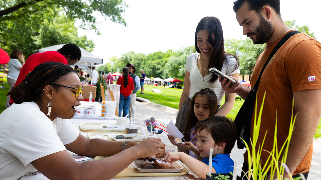 Bellodgia Roberson, a graduate student in agronomy, helps 3-year-old Jasper Molina make a soil profile during an East Campus Discovery Days event in June 2025 (image credit: Liz McCue | University Communication and Marketing).