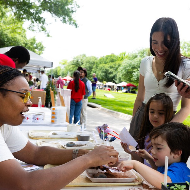Bellodgia Roberson, a graduate student in agronomy, helps 3-year-old Jasper Molina make a soil profile during an East Campus Discovery Days event in June 2025 (image credit: Liz McCue | University Communication and Marketing).