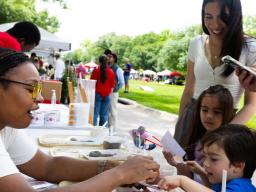 Bellodgia Roberson, a graduate student in agronomy, helps 3-year-old Jasper Molina make a soil profile during an East Campus Discovery Days event in June 2025 (image credit: Liz McCue | University Communication and Marketing).