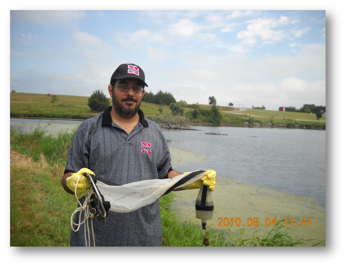 Maitham Al-Sammak used a net to collect algae samples for his dissertation on neurotoxins in Nebraska lakes.