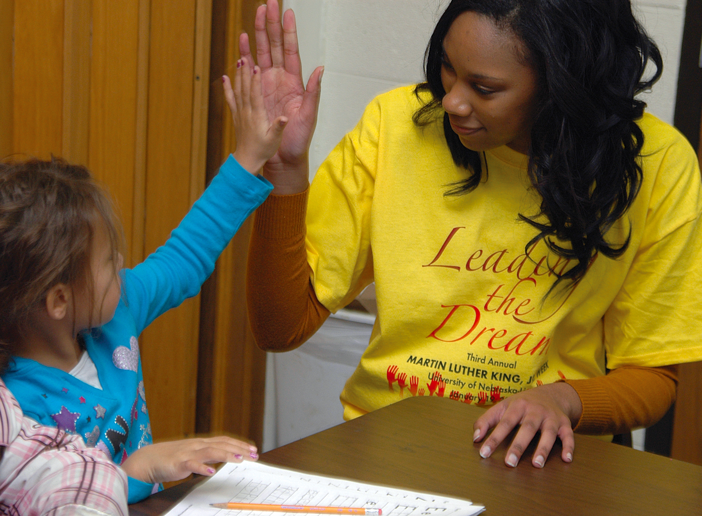 UNL student Rhaniece Choice offers a high five to an elementary school student during an Martin Luther King Jr. outreach event earlier this year.