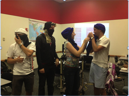 Gwyneth Talley teaches Grant Isaacson, (from left) Morgan Quijano and Adam Záhradník to wrap turbans during the UNL Globetrotters meeting on Oct. 23.  Talley acquired the skill while studying abroad in Morocco. 