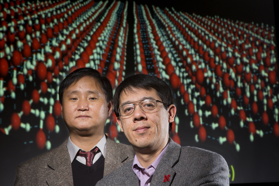Jaeil Bai (left) and Xiao Cheng Zeng. Projected behind them is a computer model of the square nanotube array, a new two-dimensional ice form they discovered.