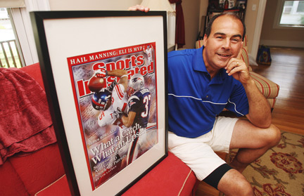 Sports Illustrated photographer Damian Strohmeyer holds one of his most famous photos from Super Bowl 42, of the key plays in the game. (Photo courtesy of The Lexington Minuteman/Ann Ringwood.)