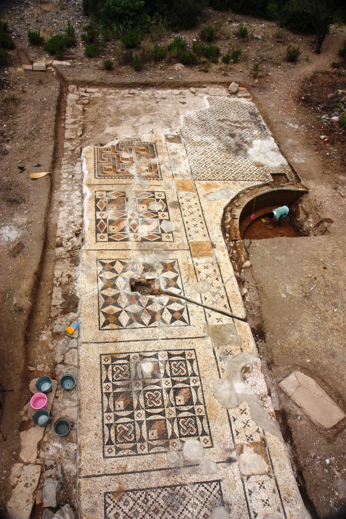 An overhead perspective of the roughly 40 percent of the Roman mosaic uncovered so far. The mosaic measures approximate 25 meters by seven meters and served as the forecourt for the adjacent large bath. Researchers expect its total area to be about 1,600 