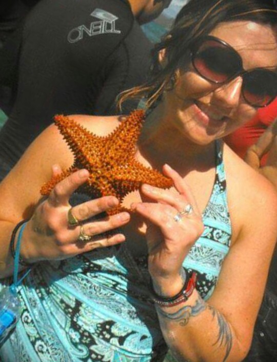 Jesy Hansen holds a starfish just before snorkeling on a reef near La Parguera, Puerto Rico.