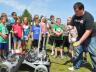 Joe Bartels (right) shows Zeman Elementary students how a robot developed by UNL engineering students will be used to pick up rocks. The robot was developed for a NASA-led robotics competition.