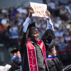 LeRoy Ford holds up his diploma for his family and friends to see.  (Photo courtesy of  Craig Chandler | University Communications)