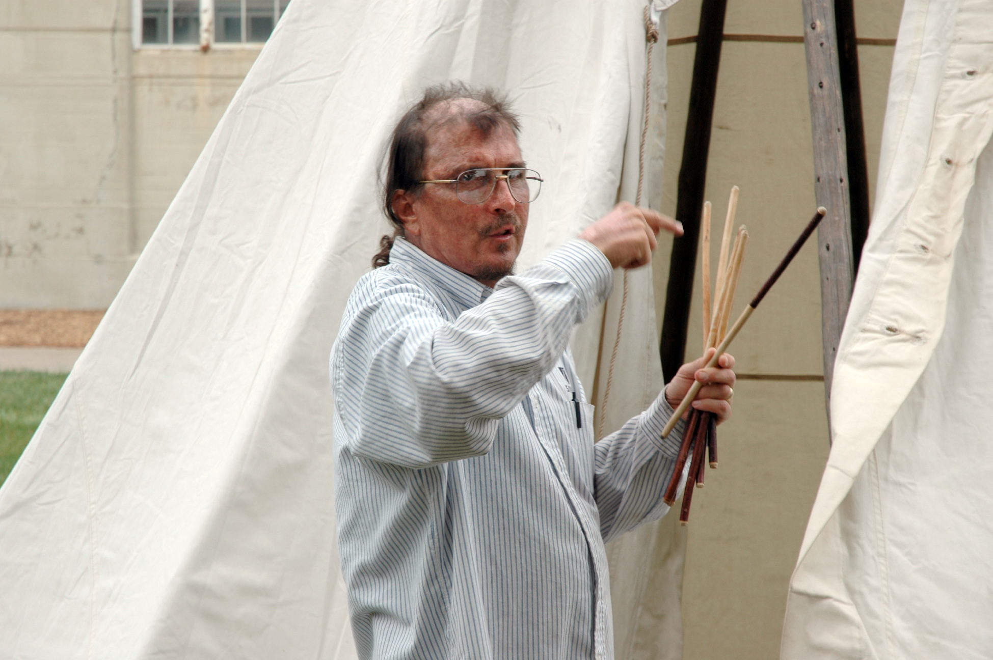 Mark Awakuni-Swetland describing the use of the chokecherry lacing pins for buttoning up the front of the tipi to his Omaha language class on the lawn east of Memorial Stadium in 2004.