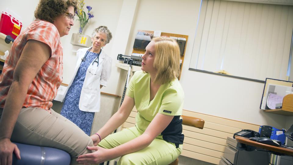 Ashley Stelling, a student in the Humanities in Medicine program, examines a patient in the University Health Center. Management of the UHC will transfer to the University of Nebraska Medical Center on July 1. (Craig Chandler | University Communications)