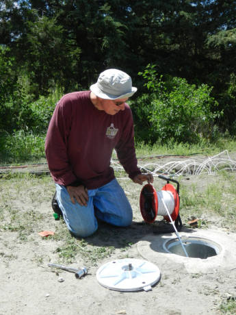 University of Nebraska-Lincoln soil environmental chemist Steve Comfort takes contamination readings from a test well near Grand Island, where he and his students are partnering with Airlift Environmental LLC to test new groundwater cleanup techniques at 