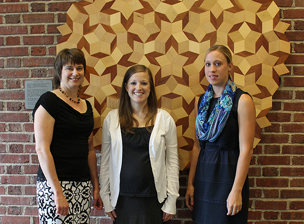 From left: Kelli Roeber-Schoening, Tiffany Powers and Shannon Wiig, who all earned their MAT degrees on August 16, 2014, worked on a mathematics problem involving the Penrose tilings as shown in this display in Avery Hall.