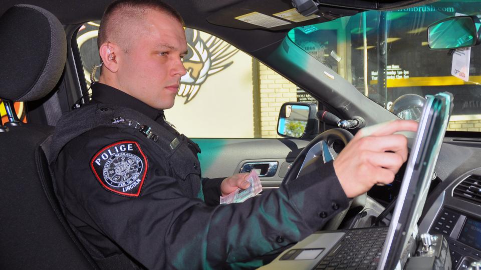Officer Eric Fischer accesses a driver's information during a stop on Oct. 17. The UNL Police Department is seeking accreditation from the Commission on Accreditation for Law Enforcement Agencies. (Troy Fedderson | University Communications)