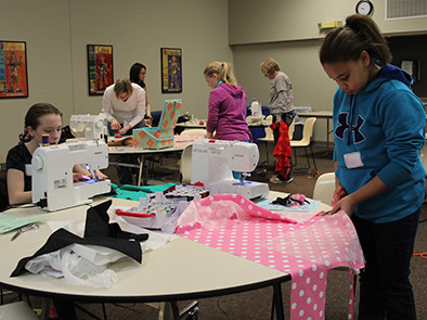 Pictured are 4-H'ers learning beginning sewing skills at the 2014 "Pillow Party" sewing workshop.