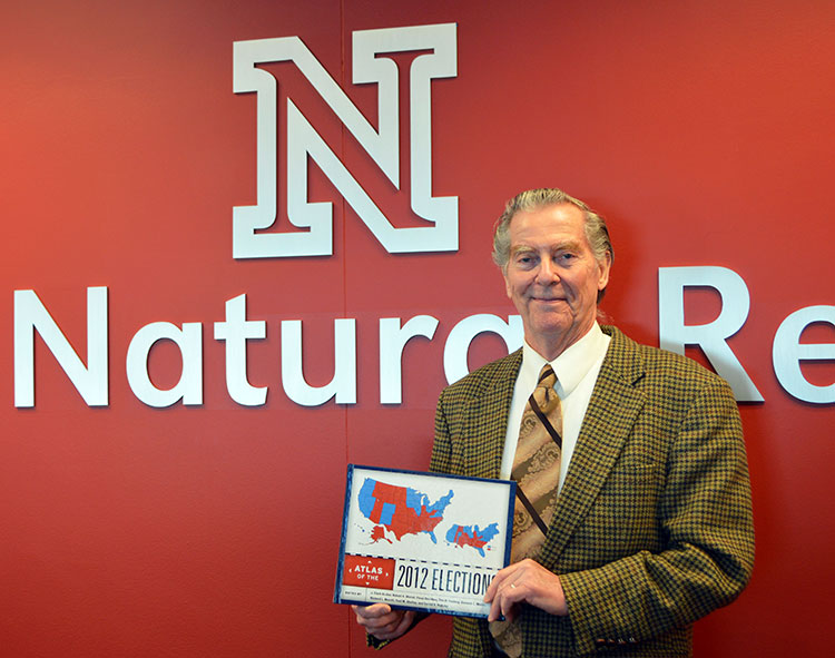Clark Archer holds his new book, "Atlas of the 2012 Elections." (Mekita Rivas | Natural Resources)