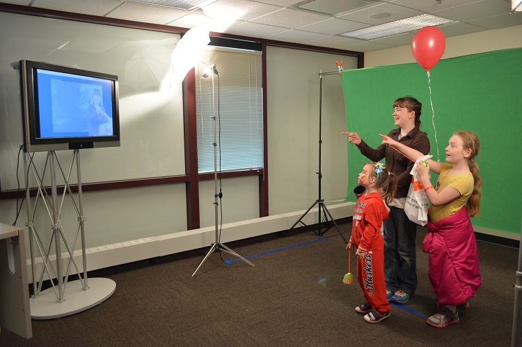 Weatherfest attendees try out their weathercasting skills in the "Green Screen Experience" room. (Mekita Rivas | Natural Resources)