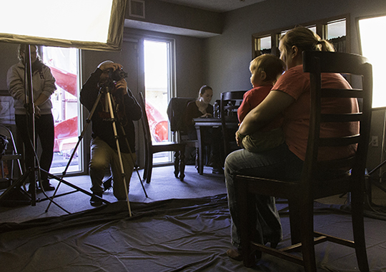 John David Richardson (behind the camera) composes a family portrait while Emily Wiethorn edits and prints photos for participants at Help Portrait on Dec. 6. Richardson and Wiethorn are graduate students in photography at UNL.