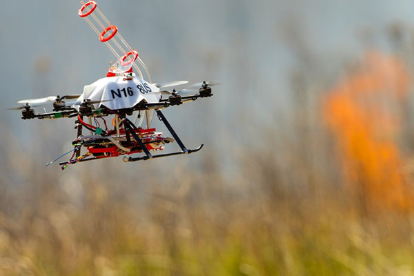 A UNL-designed drone returns to the side of a burn area for a reload of fireballs and the chemical to make them burn. Craig Chandler, UComm