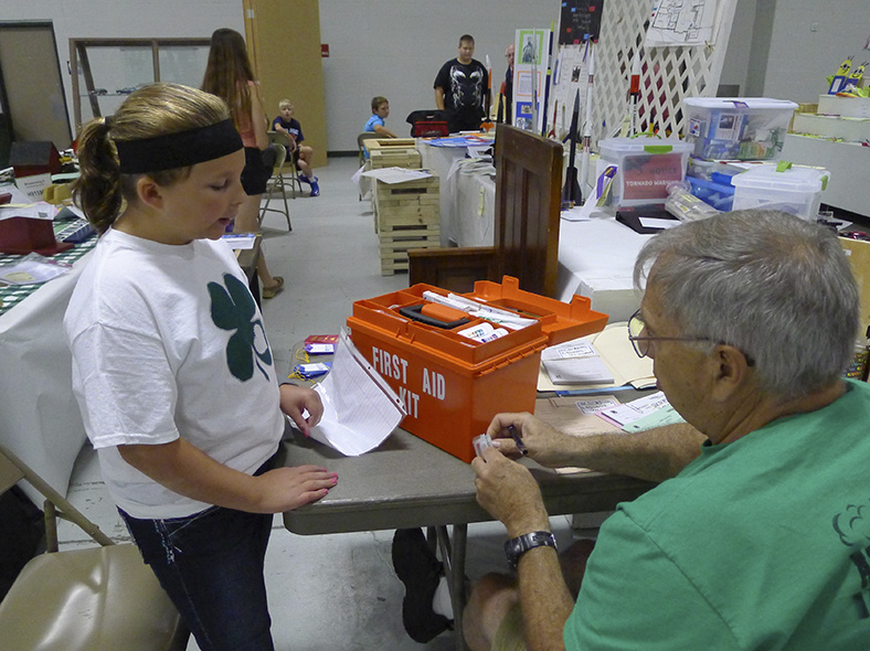 A 4-H member discusses her First Aid Kit with the judge at the 2015 Lancaster County Super Fair.