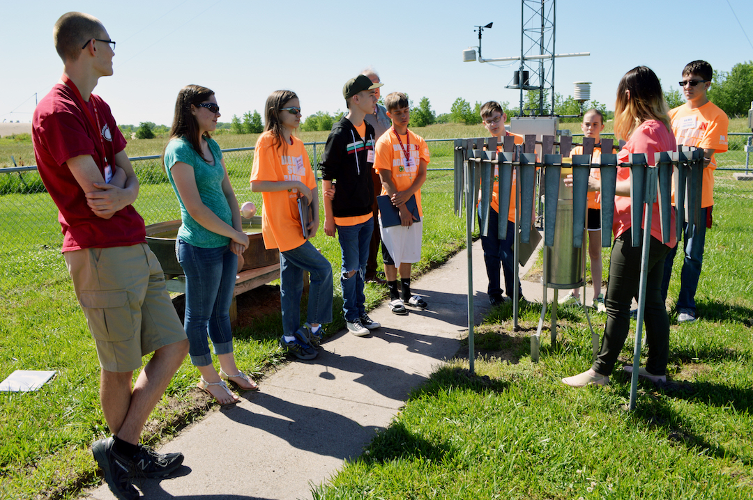 Barb Mayes Boustead, National Weather Service meteorologist and University of Nebraska-Lincoln graduate, gives Weather Camp students information on the rain gauge and its data Tuesday, June 7, 2016, at the station in Valley, Nebraska.