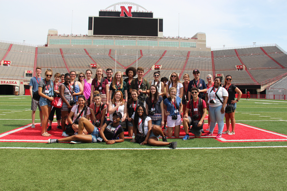 Media Academy students pose at Memorial Stadium with team leaders and professors