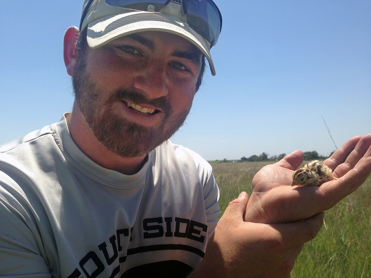 Trey Lindsey holds a pheasant chick while working outside of Culbertson, Nebraska, during this summer’s field work.   ( Courtesy photo | Claire Helmke)