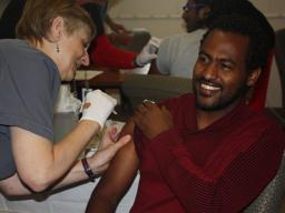 Student Yirga Wondemanhe rolls up his sleeve for a flu shot from a University Health Center nurse.