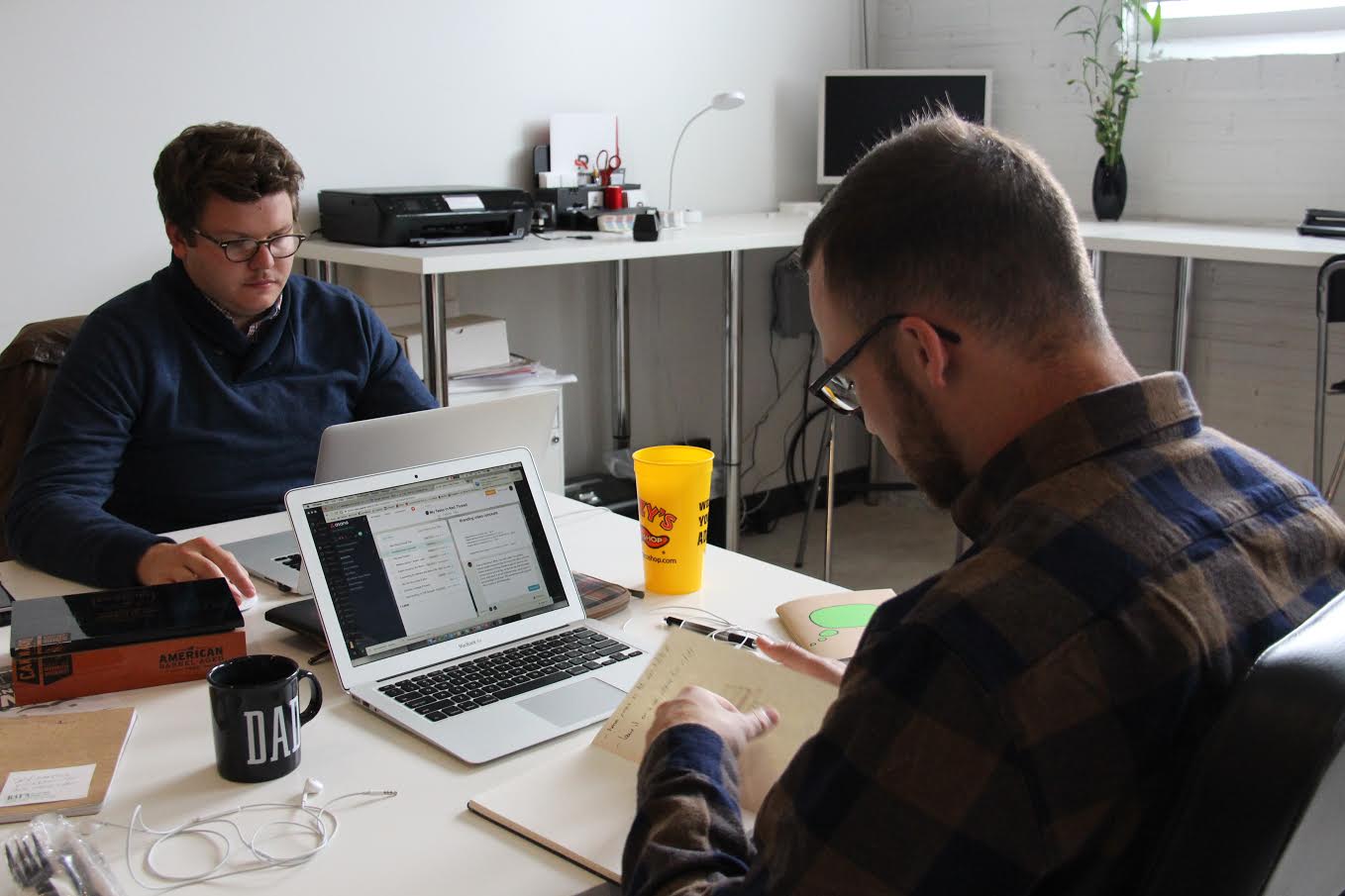 Brendon Henning (right) searches through his sketch book to find one of his commercial ideas that he thought of in September. The sketch book contains hundreds of tiny drawings.