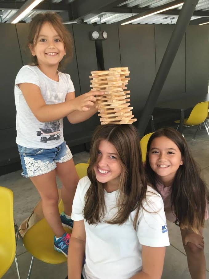 CoJMC student Azlin Armstrong (center) enjoys a game of Jenga with her campers in Istanbul, Turkey. 
