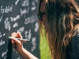 A student writes about what sustainability means to her on a Nebraska-shaped chalkboard during the university's 2016 Earth Day celebration in April.