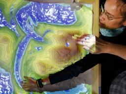  Leilani Arthurs, assistant professor of Earth and atmospheric sciences, sculpts a river bed into the new augmented-reality sandbox in Bessey Hall. Craig Chandler | University Communication
