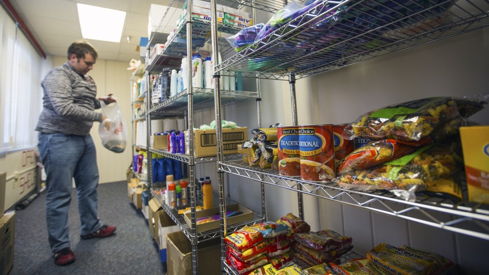Cody McCain, a sophomore accounting and agribusiness major from Aurora, places donations on shelves in the university's current food pantry. McCain is the coordinator for the food pantry, which is located in the Lutheran Center. The university is opening 