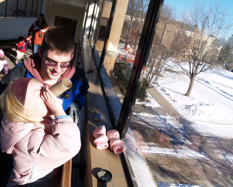 An early childhood education major helps a Ruth Staples Childhood Development Laboratory student examine an evergreen on East Campus. The gift from Susie Buffett will tap into NU's early childhood expertise, including UNL's Ruth Staples Lab. 