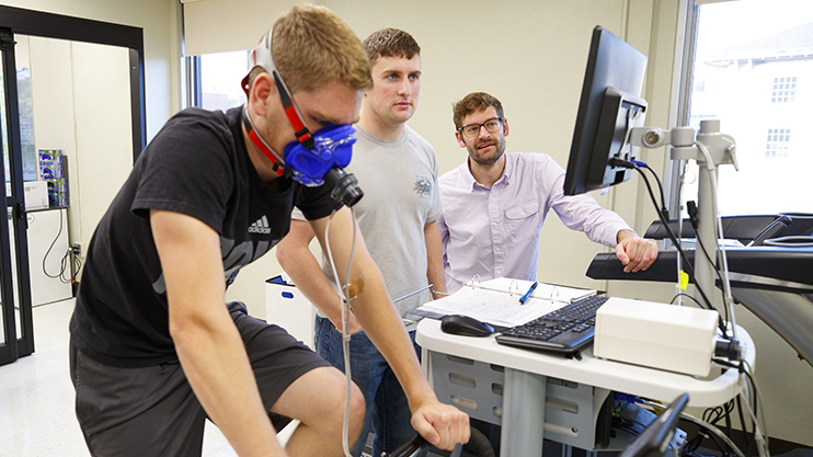 Assistant professor Karsten Koehler (far right) works with students in his exercise science lab in the Department of Nutrition and Health Sciences.