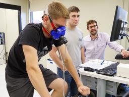 Assistant professor Karsten Koehler (far right) works with students in his exercise science lab in the Department of Nutrition and Health Sciences.