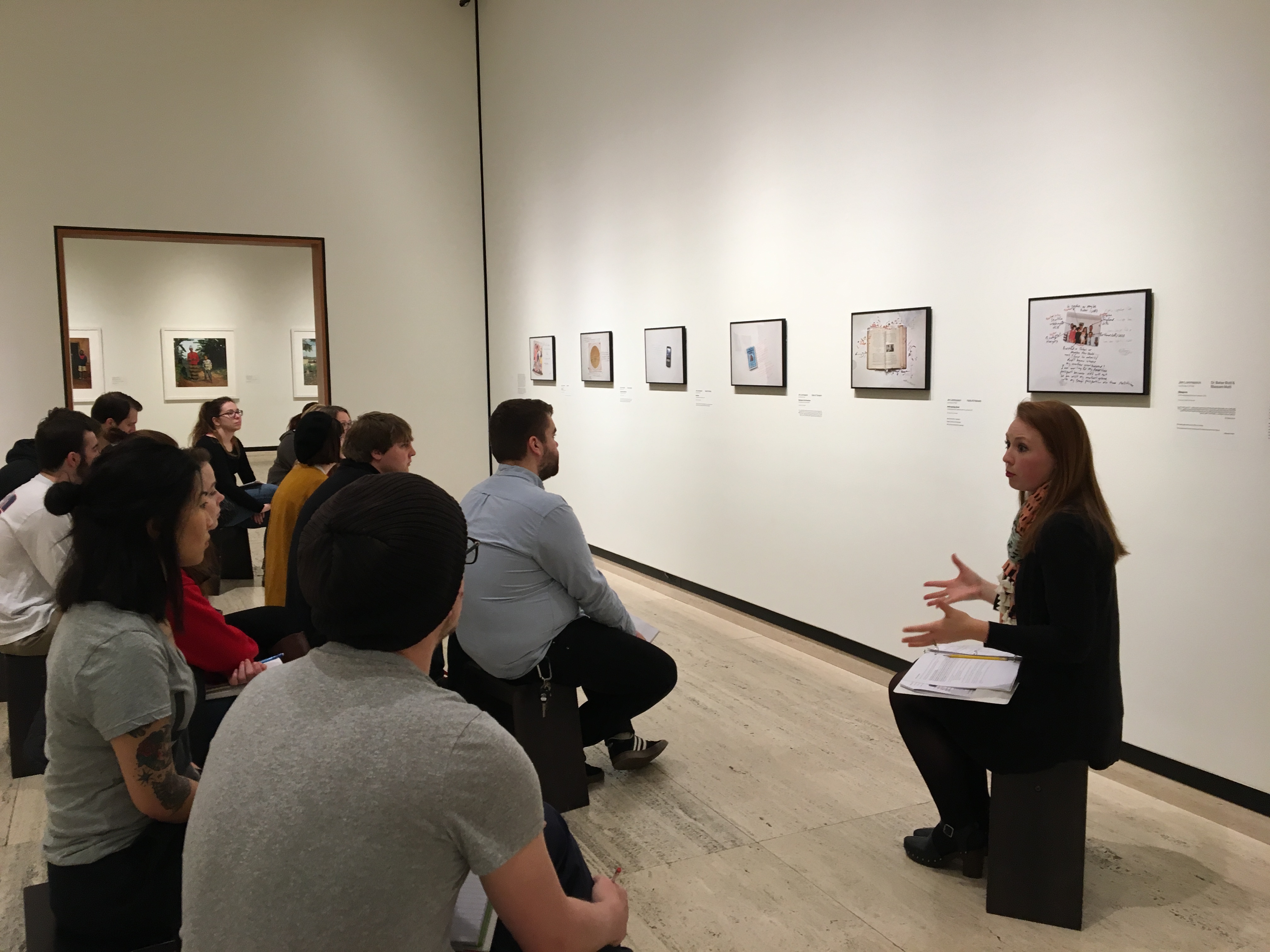 Students in the Nebraska Mosaic class listen as Abby Groth, assistant curator of public programs, (far right) discusses the nuances of Jim Lommasson’s exhibit at the Sheldon Art Museum. (Photo by Michelle Hassler)