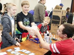 Ryland Aksamit and Terry Glantz, both of Lincoln, push “fog” out of a bottle during the 17th annual Weatherfest  on Saturday, April 1, at Nebraska Innovation Campus. At right, Aiden Powers of Ceresco looks on. | Shawna Richter-Ryerson, Natural Resources