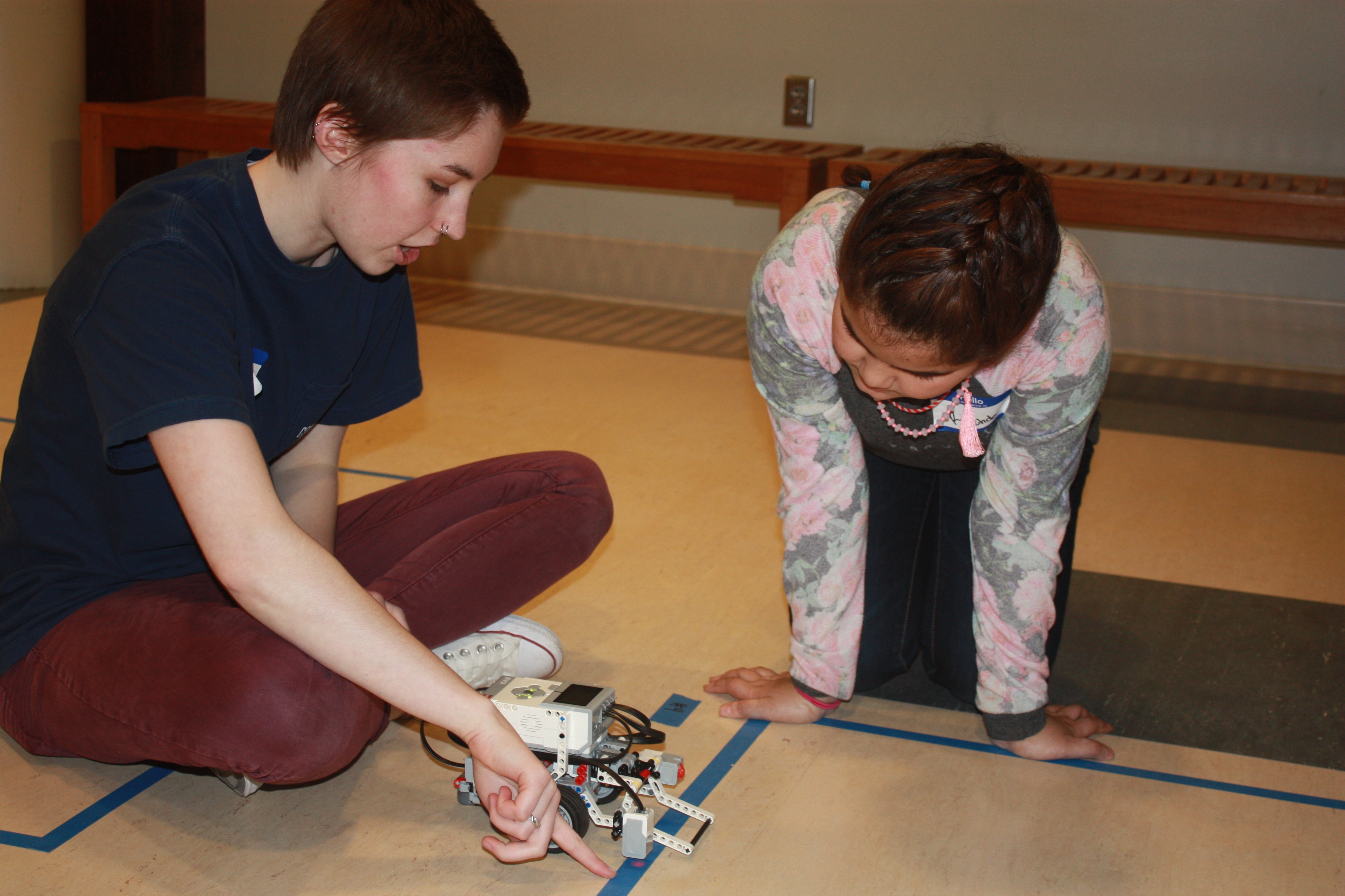 Computing for All member Allison Buckley helps a Girl Scout program a robot at last month's Girl Scout camp.