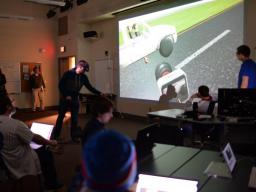 Film and New Media Senior Ben Hartzell (in VR goggles on left) shows the progress of his team's final project in class on April 10. Photo by Michael Reinmiller.