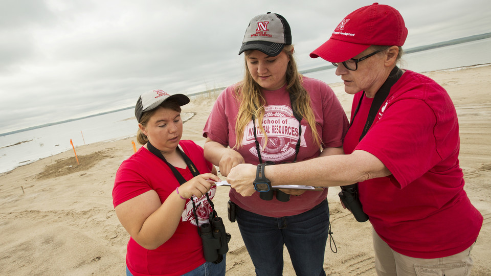 Mary Bomberger Brown (right) discusses Piping Plover habitat with students (left) Peyton Burt and Jessica Tramp at Lake McConaughy. | University Communications file photo